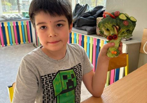 Chłopiec prezentuje swoją postać z brokułu i innych warzyw.