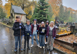 Uczniowie klasy 7b podczas kwesty na Starym Cmentarzu, w tle nagrobki cmentarza.