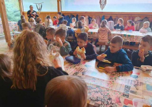 Klasa 2a i 3a podczas posiłku w Konarzewie, uczniowie siedzą przy długich ławach.