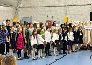 Uczniowie klasy 2a i klas 6 stojący podczas przedstawienia.