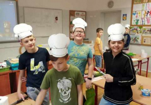 Uczniowie z 3a w czapkach kucharskich podczas kulinarnych działań.