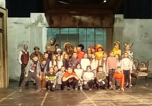 Zdjęcie grupowe uczniów i aktorów w kostiumach ze spektaklu.