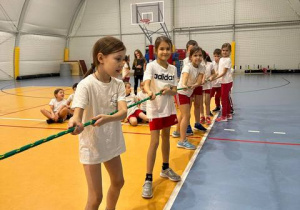 Grupa uczniów przygotowuje się do przeciągania liny.