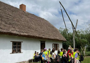 Uczniowie prze chatą w skansenie.