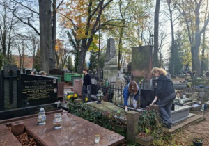 dzieci sprzątające groby na cmentarzu