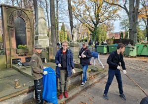 dzieci sprzątające groby na cmentarzu