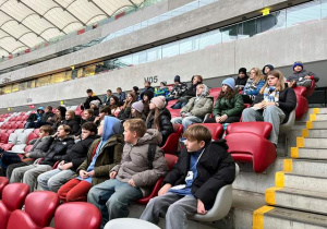 Uczniowie siedzą na trybunie dla VIP, na stadionie w Warszawie.