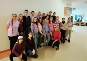 Uczniowie klasy 5a pozują do zdjęcia na korytarzu szkolnym ubrani są kolorze fioletowym