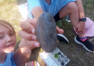Dziewczynki prezentują zebrane podczas spaceru skarby.