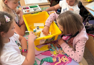 Dziewczynki układają klocki lego, które zaprogramują.