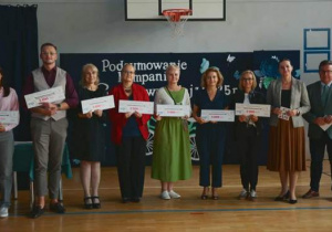 Dyrektorzy i nauczyciele odbierający nagrody w postaci voucherów