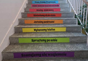 Naklejki na schodach z zasadami dobrego zachowania.