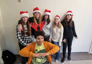 5 dziewczyn w czapkach Mikołaja i 1 chłopiec z czerwonym rogami renifera