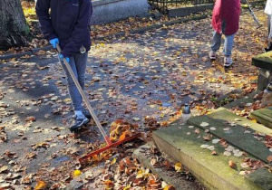 Dziewczynki porządkują groby na Starym Cmentarzu