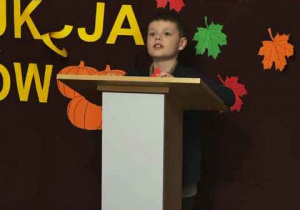 Chłopczyk za mównicą, prowadzi aukcję bukietów.