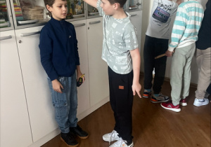 Uczniowie mierzą swój wzrost.