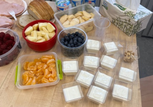 Owoce, jogurty, przekąski jako składnik zdrowego śniadania.