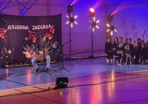 Młoda dziewczyna gra na gitarze i śpiewa.