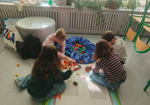 Grupa uczniów przy jednym z zestawów Lego.