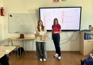 Nauczyciel wraz z uczennicą na podsumowaniu konkursu matematycznego.