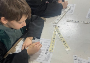 Chłopcy podczas zajęć kaligrafii.