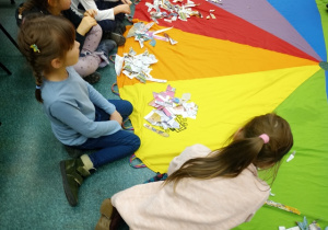 Uczniowie siedzą wokół kolorowego koła