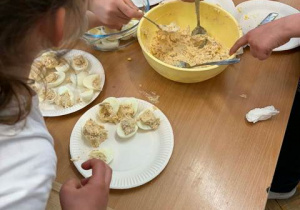 Uczniowie faszerują jajka.