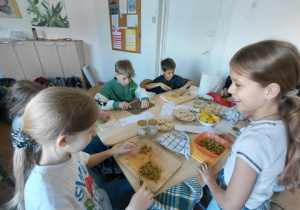 Grupa uczniów, przygotowuje tapas z oliwek.