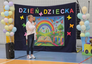 Pani Dyrektor na tle dekoracji z okazji Dnia Dziecka.
