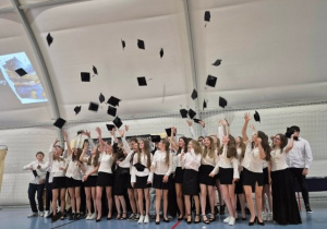 Absolwenci klas 8 podrzucają birety.