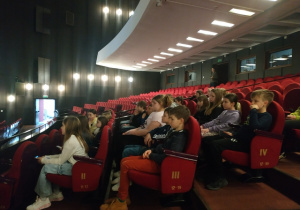 Uczniowie siedzą na widowni teatru