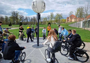 Uczniowie siedzą na rowerach w kręgu