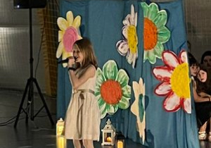 Dziewczynka na tle kolorowej dekoracji śpiewa