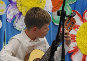 Chłopiec grający na gitarze klasycznej