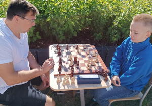Rozgrywka szachowa między uczniem a rodzicem.