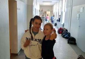 Dwie dziewczynki z 6b w swoich nowych fryzurach na szkolnym korytarzu.